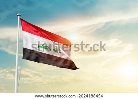 Iraq national flag waving in beautiful clouds.