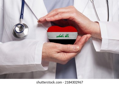 Iraqi Doctor Holding Heart With Flag Of Iraq Background. Healthcare, Charity, Insurance And Medicine Concept