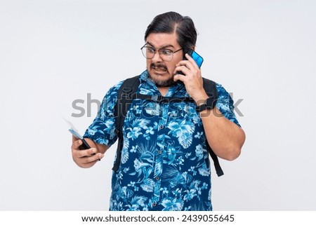 Irate middle-aged man in a floral shirt making a demanding call to a travel agency, isolated on a white backdrop.