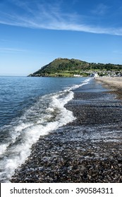 Ireland, County Wicklow, Bray: Shoreline of Irish spa seaside resort Bray with waves, Bray Head and blue sky in the background.