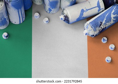 Ireland flag and few used aerosol spray cans for graffiti painting. Street art culture concept, vandalism problems - Powered by Shutterstock