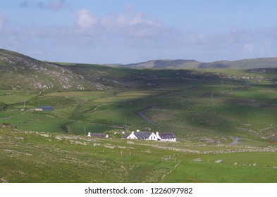 Ireland Lanscape With Farm In The Middle. Mountains And Walled Fields With Clouds Above.