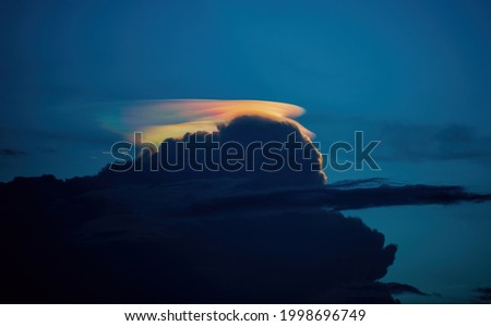 Iridescent pileus cloud in the rain