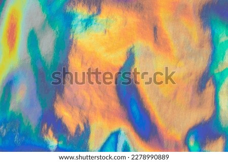Iridescent rainbow-colored texture with a shining surface. Abstract background