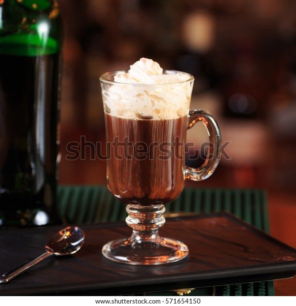 Irish coffee in a\
bar. Concept of St Patrick holiday. Holiday background. Irish\
national day. Warm tone.\
Square