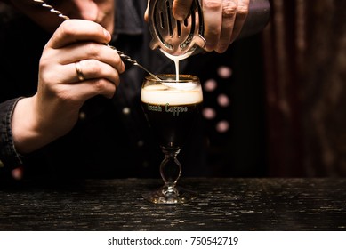 Irish Coffee cups with cream on a dark background, on the bar, warming cocktail, cooking process