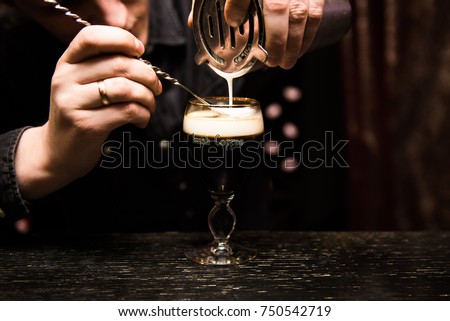 Irish Coffee cups with cream on a dark background, on the bar, warming cocktail, cooking process