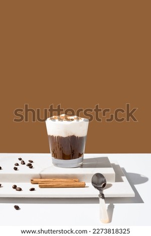 Irish coffee with whipped cream and cinnamon on a brown background
