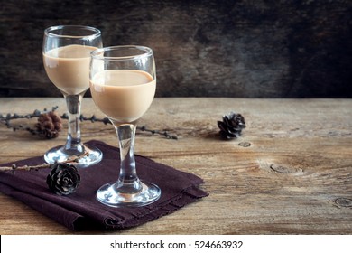 Irish Cream Coffee Liqueur, Christmas Decoration And Cones Over Rustic Wooden Background - Homemade Festive Christmas Alcoholic Drink