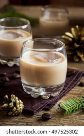 Irish Cream Coffee Liqueur With Ice, Christmas Decoration And Ornaments Over Rustic Wooden Background - Homemade Festive Christmas Alcoholic Drink