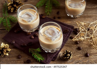 Irish Cream Coffee Liqueur With Ice, Christmas Decoration And Ornaments Over Rustic Wooden Background - Homemade Festive Christmas Alcoholic Drink