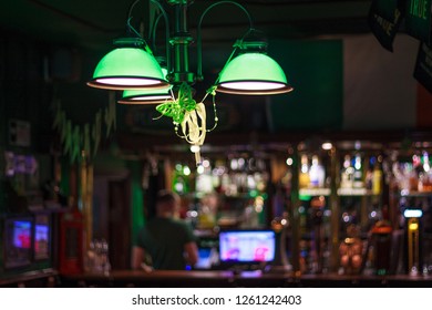 Irish Pub Inside. Photo Of The Bar Of A Green Dark Bar. Focus On The Chandelier.