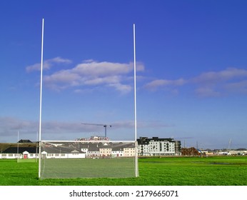 Irish sport tall goal posts in a field on a bright sunny day. Galway city, Ireland. South park. Camogie, hurling and rugby training ground. Blue cloudy sky. Selective focus