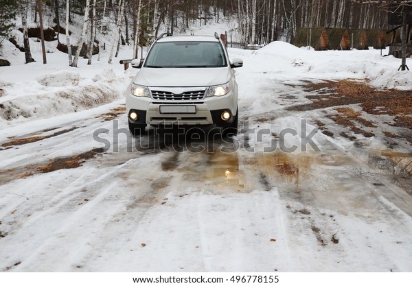 Irkutsk, Russia - March, 21 2016: White car on\
snowy spring road\
Russia