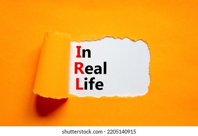 IRL In Real Life Symbol. Concept Words IRL In Real Life On White Paper On A Beautiful Orange Background. Business And IRL In Real Life Concept. Copy Space.