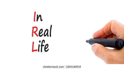 IRL In Real Life Symbol. Concept Words IRL In Real Life On White Paper On A Beautiful White Background. Businessman Hand. Business And IRL In Real Life Concept. Copy Space.