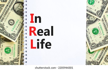 IRL In Real Life Symbol. Concept Words IRL In Real Life On White Note On A Beautiful Background From Dollar Bills. Business And IRL In Real Life Concept. Copy Space.