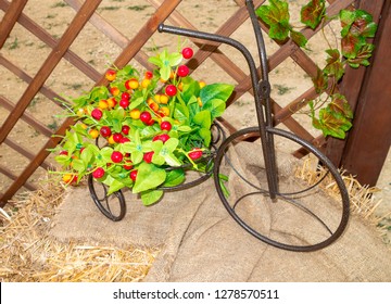 Iron artificial small tricycle on which lies a basket with decorative artificial fruits of red and yellow cherries - Powered by Shutterstock