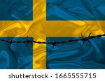 iron barbed wire against the background of the national silk flag of the state of Sweden, the concept of imprisonment for offenders, for the siege area