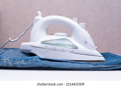 Iron And Blue Jeans. Ironing Pants