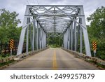 The iron bridge across Cuyahoga river on Ohio, with the automotive road and scenic nature forest around.
