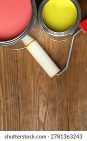 Iron can of bright paint and brush on wooden background, top view
