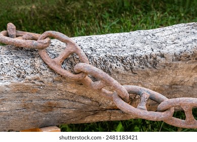 iron chain corroded by rust on the background of a wooden beam close-up - Powered by Shutterstock