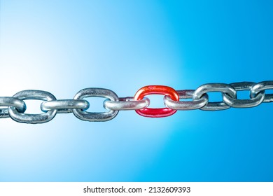 Iron Chain With Red Link On Blue Background With Copy Space. Weak Link Concept.