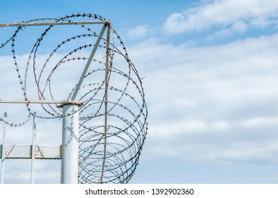 Iron Fence With Barbed Tape On Blue Sky