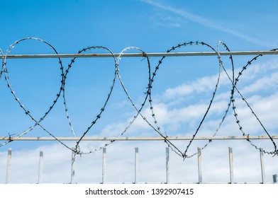 Iron Fence With Barbed Tape On Blue Sky