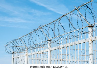 Iron Fence With Barbed Tape On Blue Sky