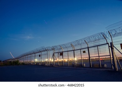 iron fence with barbed wire at the airport - Powered by Shutterstock