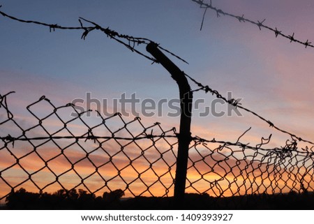 Similar – Fence with a barbed