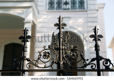 an iron fence in front of an antebellum mansion in the New Orleans Garden District