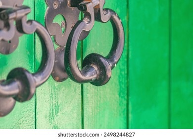 Iron forged handle bell on door with protruding part for easy hand grip to open or knock on door, thereby giving signal to open. Ancient devices, element of decoration created by forging metal. - Powered by Shutterstock