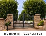 Iron front gate of a beautiful luxury home. Fancy large mansion behind a locked gate. Nobody, street photo, selective focus