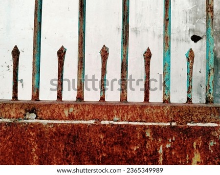 The iron gate is rusted, iron fence and door, looks rusty, due to age, in a house that is not maintained, with iron fence and door, pintu besi berkarat di rumah yang tidak terawat, cat menelupas