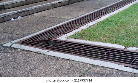 Iron Grate Of A Drainage System For Storm Water Drainage In Side A Pedestrian Sidewalk