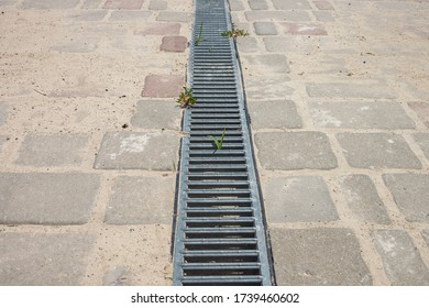 Iron Grate Of Storm Water Runoff On The Sidewalk