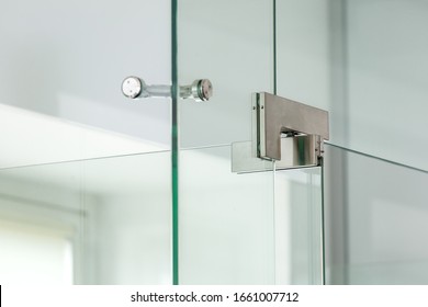 Iron Hinges Of A Glass Door On Bathroom At The Corner Junction Of A Glass Construction, Close Up.