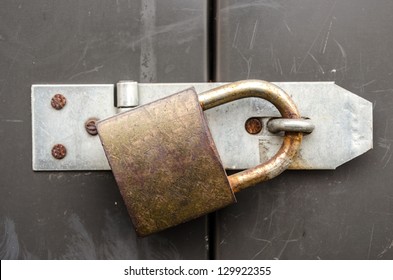 Iron lock and chain on an old door - Shutterstock ID 129922355