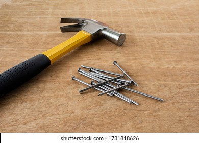 Iron Nail On A Wooden Table, Using Hammer And Nail On Wood  Background.