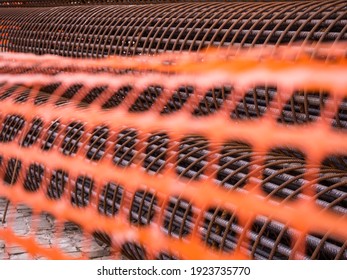 Iron On Construction Site. Rusty Iron Bundle For Making Reinforcement Concrete And Plastic Orange Net. Rebar For Reinforce Hole In The Ground. Texture Background Net Metal Red