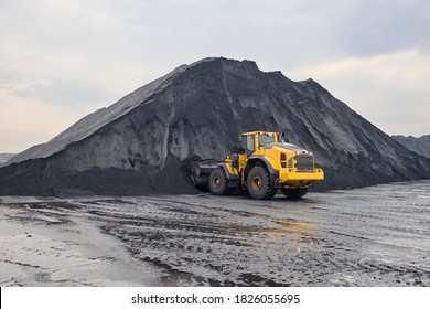 Iron ore stockpile at cargo terminal storage sites during cargo operation using wheel loader - Shutterstock ID 1826055695