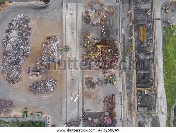 Iron raw materials recycling pile, work\
machines. Metal waste junkyard. View from\
above.
