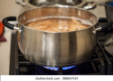 Iron silver pot standing on the gas on the fire on the stove. It boiled shrimp