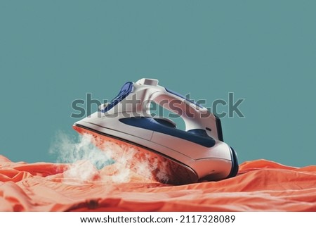 Iron smoothing clothes on the ironing board, household chores concept