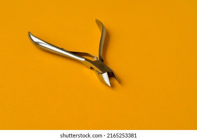 Iron Tool Cuticle Nippers Close-up On A Bright Yellow Background