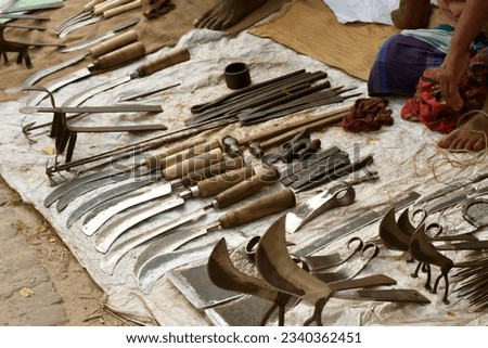 Iron tools for kitchen, farming, construction and other purposes are on display in a remote village blacksmith's shop for sale