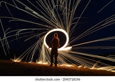 Iron wool circle drawing light fireworks. Burning Steel Wool spinning, Trajectories of burning sparks at night. Movement light effect, steel wool fire hoop. long exposure light painting, Pyrotechnic - Powered by Shutterstock